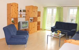 a living room with two blue chairs and a tv at "Hof Triangel - Whg 2" - Bauernhofurlaub in Riepsdorf