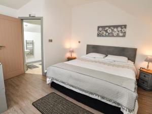 a bedroom with a large bed and a mirror at Plas Bach in Aberffraw