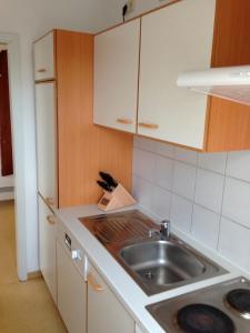 - une cuisine avec un évier et un comptoir dans l'établissement Ferienwohnung Ertl - 14518, à Petersdorf auf Fehmarn