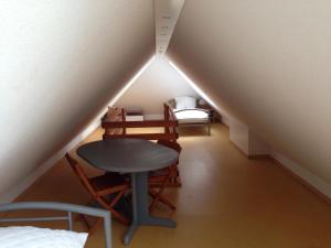 een kamer met een tafel en stoelen op een zolder bij Ferienwohnung Ertl - 14518 in Petersdorf auf Fehmarn