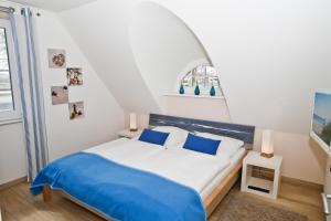 レリクにあるFerienhaus Meerzeitのベッドルーム1室(大型ベッド1台、青い毛布付)