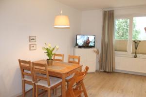 a dining room with a table and chairs and a television at Landhaus Lippmann Whg3 in Grönwohldshorst