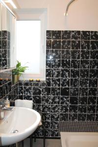 a bathroom with a sink and a black tiled wall at Landhaus Lippmann Whg3 in Grönwohldshorst