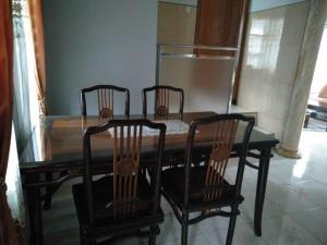 a dining room table with four chairs around it at Villa Trijaya in Batu