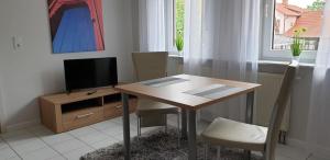 a dining room with a table and a television at Ferienwohnung Bernhard in Germersheim