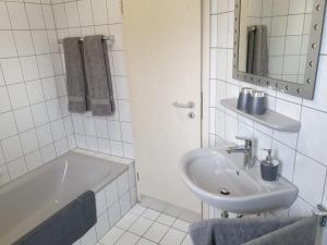 a white bathroom with a sink and a bath tub at Ferienwohnung Bernhard in Germersheim