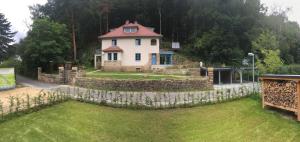 ein Haus auf einem Hügel mit einer Steinmauer in der Unterkunft Prima Klima Villa - Ferienwohnung Steinbrecher in Struppen