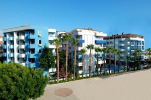 a row of apartment buildings with palm trees and a beach at Kleopatra Ramira Hotel - All Inclusive in Alanya