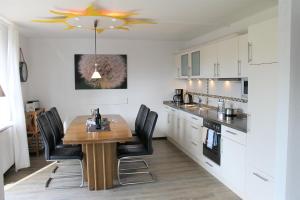 cocina con mesa de madera y sillas negras en "Ferienhaus Sternchen" für die große Familie en Grömitz