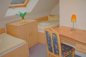 a small bedroom with a desk and a chair at Am Deich 33 in Zingst