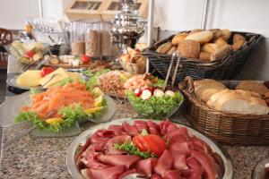 un buffet de diferentes tipos de comida en una mesa en Hotel Villa Undine en Grömitz