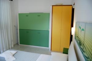 a room with a green refrigerator and a yellow cabinet at Albergo Belvedere in Ventotene