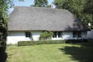 a white house with a thatched roof at Hus Boompecker in Achtrup