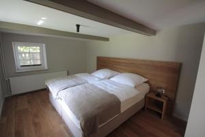 a bedroom with a large bed with a wooden headboard at Hus Boompecker in Achtrup