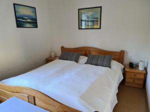 ein Schlafzimmer mit einem Holzbett mit zwei Nachttischen in der Unterkunft Ferienwohnung Rosenthal in Grömitz
