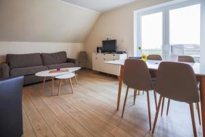 een woonkamer met een bank en een tafel en stoelen bij Ferienhof Büdlfarm - Sperlings Lust in Sahrensdorf