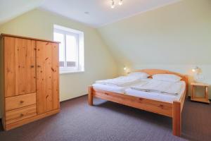 - une chambre avec un grand lit et une armoire en bois dans l'établissement Ferienhof Büdlfarm - Sperlings Lust, à Sahrensdorf