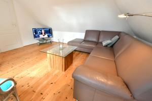 a living room with a brown couch and a table at Seeblick 8, PP außen in Zingst