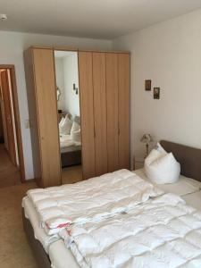 a bedroom with a large white bed and a mirror at Meerlust App 6 in Zingst