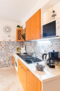 a kitchen with wooden cabinets and a counter top at Apartmani Vesna Tuheljske toplice in Tuheljske Toplice