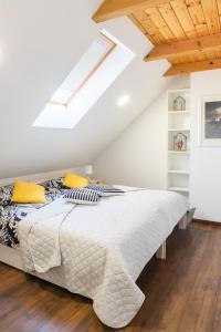 biała sypialnia z łóżkiem na poddaszu w obiekcie Apartmani Vesna Tuheljske toplice w mieście Tuheljske Toplice