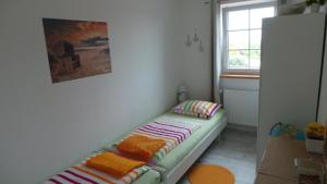 ハイリゲンハーフェンにあるFerienwohnung Ihleの小さな客室で、ベンチ(枕付)が備わります。