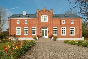 a large red brick house with flowers in front of it at Knusthof - Wohnung 2 in Strukkamp auf Fehmarn