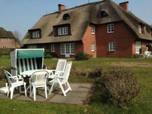 a group of chairs and a table in front of a house at Haus Bornholm Whg Anemone in Nieblum