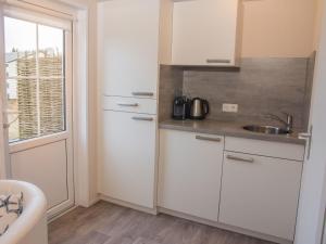 沙博伊茨的住宿－Welle 34a，厨房配有白色橱柜、水槽和窗户。