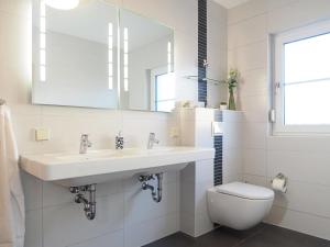 a white bathroom with a sink and a toilet at Am Paalen 2 Whg 1 in Zingst