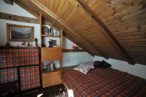 - une chambre avec un lit et un plafond en bois dans l'établissement Chalet Charbonnier, à Wolpadingen