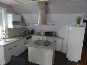 cocina con armarios blancos y encimera en 5-Sterne-Fewo "Brillant" en Allenbach