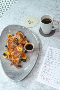a plate with french toast and a cup of coffee at Kimpton Banneker Hotel, an IHG Hotel in Washington
