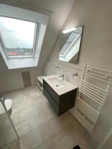 ein Bad mit einem Waschbecken, einem Spiegel und einem Fenster in der Unterkunft Kabine 12 in Grömitz