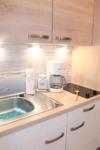 a kitchen counter with a sink and a coffee maker at "Haus Sonnenschein - Whg 3" familiengerechte Wohnung mit 2 SZ und Terrasse in zentraler Lage in Grömitz