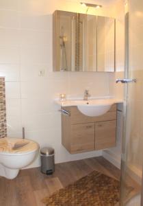 een badkamer met een wastafel en een toilet bij "Haus Sonnenschein - Whg 3" familiengerechte Wohnung mit 2 SZ und Terrasse in zentraler Lage in Grömitz
