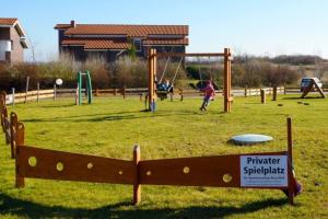 un parque con parque infantil con gente jugando en FEWO Kornblume en Hohen Wieschendorf