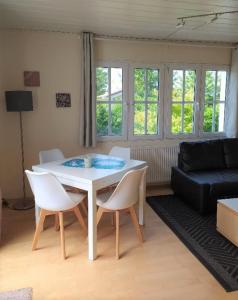 - un salon avec une table et des chaises blanches dans l'établissement Hanse 4, à Lensterstrand
