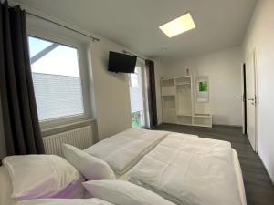a bedroom with a large white bed and a window at Alte Molkerei FeWo 2 in Zilly