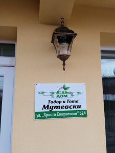 um sinal na lateral de um edifício com uma luz de rua em дом Тодор и Тота Мутевски em Troyan