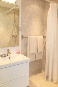 een badkamer met een wastafel en een douche met handdoeken bij "Garten" in Grömitz