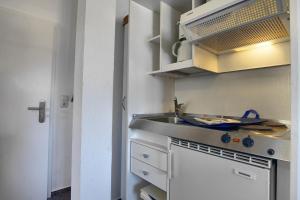 a small kitchen with a sink and a stove at Altes Wasserwerk, App 8 in Zingst