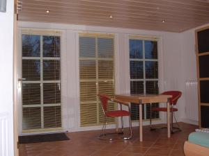 een kamer met een tafel, stoelen en ramen bij Appartement Altes Land Jork bei HH in Jork