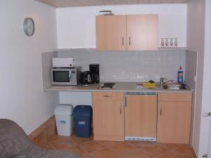 una pequeña cocina con fregadero y microondas en Appartement Altes Land Jork bei HH en Jork