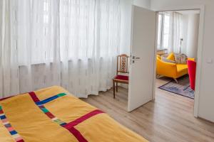 um quarto com uma cama, uma cadeira e uma janela em Hverfisgata Apartment em Reykjavík