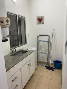 a white bathroom with a sink and a mirror at Departamento Tafí Viejo in Tafí Viejo