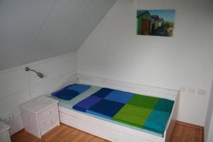 a bed in a room with a painting on the wall at Ferienhaus 3370 in Tossens in Butjadingen OT Tossens