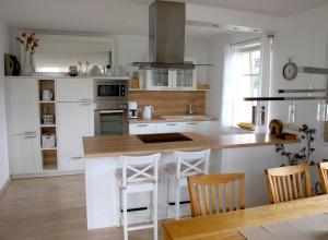 a kitchen with a counter and some chairs in it at DHH Wiesenstraße 55 - Dünensand in Zingst