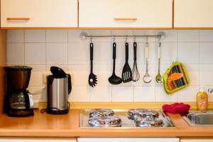 un bancone della cucina con utensili appesi al muro di Villa Christiana - Ginster a Graal-Müritz
