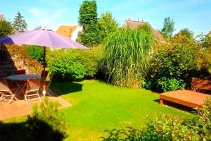 a garden with an umbrella and a table and chairs at Sonnenschein in Zingst